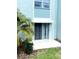 Small patio with sliding glass door, awning, and well-maintained landscaping at 1706 Belleair Forest Dr # 146, Belleair, FL 33756