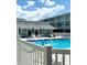 Community pool with chairs and tables for relaxing, with a view of the building at 1706 Belleair Forest Dr # 146, Belleair, FL 33756