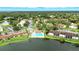 An aerial view of a community featuring a sparkling pool, lush landscaping, and a picturesque lake, perfect for outdoor activities at 1725 Pine Ridge E Way # E, Palm Harbor, FL 34684