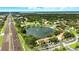 Aerial view of community with a central lake featuring a fountain and a pool at 1725 Pine Ridge E Way # E, Palm Harbor, FL 34684