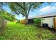 Spacious backyard featuring lush green grass, a mature tree, and a screened patio area at 1725 Pine Ridge E Way # E, Palm Harbor, FL 34684