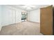 This carpeted bedroom has sliding door access to a sunroom, ceiling fan, and a double door closet at 1725 Pine Ridge E Way # E, Palm Harbor, FL 34684