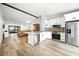 Modern kitchen with stainless steel appliances, white cabinets, granite countertops, with open access to the living space at 1725 Pine Ridge E Way # E, Palm Harbor, FL 34684