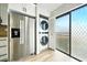 A modern kitchen with stainless steel refrigerator, convenient laundry closet and access to outdoor balcony and beautiful views at 1725 Pine Ridge E Way # E, Palm Harbor, FL 34684