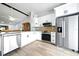 Contemporary kitchen featuring stainless steel appliances, white cabinets, granite countertops and modern fixtures at 1725 Pine Ridge E Way # E, Palm Harbor, FL 34684
