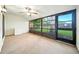 The sunroom has carpet, a ceiling fan, and floor to ceiling windows providing plenty of light at 1725 Pine Ridge E Way # E, Palm Harbor, FL 34684