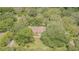 Aerial view of the house nestled amongst mature trees providing shade and privacy at 18110 30Th St, Lutz, FL 33559
