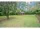 Expansive grassy yard featuring a rustic wooden barn with a fenced perimeter at 18110 30Th St, Lutz, FL 33559