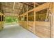 Interior of the horse barn, with individual stalls featuring wood paneling and overhead metal roof at 18110 30Th St, Lutz, FL 33559