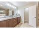 A bathroom with dual sinks, generous counter space, and a large mirror sits adjacent to a well-lit shower enclosure at 18110 30Th St, Lutz, FL 33559