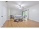 Bright bedroom featuring hardwood floors, a ceiling fan, closet, and sliding door at 18110 30Th St, Lutz, FL 33559