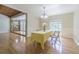 A dining room with hardwood floors and a table set for four, bathed in natural light from the nearby window at 18110 30Th St, Lutz, FL 33559