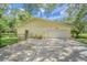 Exterior view of the home and a large driveway with a two-car garage at 18110 30Th St, Lutz, FL 33559