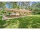 Exterior view of the home surrounded by a lush lawn and mature landscaping at 18110 30Th St, Lutz, FL 33559