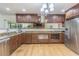 Well-appointed kitchen featuring wood cabinetry, granite counters, stainless steel appliances, and hardwood floors at 18110 30Th St, Lutz, FL 33559