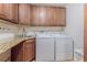 A close-up view of the laundry area, complete with an included washer and dryer, a utility sink, and ample cabinet storage at 18110 30Th St, Lutz, FL 33559