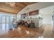 Open-concept living room featuring wood ceiling, hardwood floors, stone accents, and seamless kitchen integration at 18110 30Th St, Lutz, FL 33559