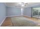 An open-concept living room showcases hardwood floors, ample natural light, a ceiling fan and neutral paint palette at 18110 30Th St, Lutz, FL 33559