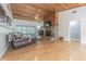 Inviting living room with a stone fireplace, wood ceiling, and natural light from large windows at 18110 30Th St, Lutz, FL 33559