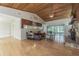 Cozy living room featuring a stone fireplace, wood ceiling, hardwood floors, and sliding glass doors at 18110 30Th St, Lutz, FL 33559