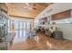 Spacious living room showcasing stone fireplace, wood ceiling, hardwood floors, and open floor plan to the kitchen at 18110 30Th St, Lutz, FL 33559