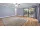 A bright living room featuring hardwood floors, soft gray walls, a ceiling fan, and access to the outdoor patio at 18110 30Th St, Lutz, FL 33559
