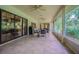 Covered patio with tile flooring, ceiling fans, sliding glass doors, dining table and chairs, and grill at 18110 30Th St, Lutz, FL 33559