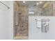 A walk-in shower with contemporary tile and multiple shower heads with convenient built-in shelving for toiletries at 18110 30Th St, Lutz, FL 33559