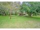 A sweeping green lawn leads to a charming gazebo, set against a backdrop of mature trees and natural beauty at 18110 30Th St, Lutz, FL 33559