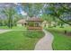 View of the backyard gazebo that sits on a large lot surrounded by mature trees and green grass at 18110 30Th St, Lutz, FL 33559
