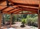 A backyard area with a wooden pergola-covered patio and lush landscaping at 1861 Harmony Dr, Clearwater, FL 33756