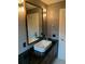 Updated bathroom with modern vanity, black countertop, and decorative lighting at 1861 Harmony Dr, Clearwater, FL 33756