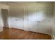 Bedroom with hardwood floors and white closets with chrome hardware at 1861 Harmony Dr, Clearwater, FL 33756