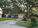 Inviting single-story home with a lush lawn, colorful landscaping, and a neatly maintained driveway at 1861 Harmony Dr, Clearwater, FL 33756
