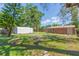 Large backyard featuring mature trees, sheds, and a fire pit at 1912 E 97Th Ave, Tampa, FL 33612