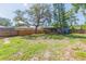 Spacious backyard featuring a covered porch, mature trees, and a wood fence at 1912 E 97Th Ave, Tampa, FL 33612