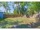 A fenced backyard with mature trees and a gate at 1912 E 97Th Ave, Tampa, FL 33612