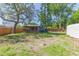 Expansive backyard with a deck, mature trees, storage shed, and wood fence at 1912 E 97Th Ave, Tampa, FL 33612