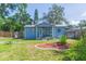 Adorable blue home with a cozy front porch and decorative landscaping at 1912 E 97Th Ave, Tampa, FL 33612