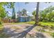 Cozy blue home with mature trees and a spacious front yard at 1912 E 97Th Ave, Tampa, FL 33612