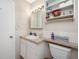 Bathroom featuring tiled walls, vanity sink, toilet and storage shelves at 211 Pasadena N Ave # 109, St Petersburg, FL 33710