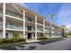 Three story condo building with palm trees and well-maintained landscaping at 211 Pasadena N Ave # 109, St Petersburg, FL 33710