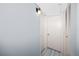 Hallway with light blue walls, modern light fixture and two white doors at 211 Pasadena N Ave # 109, St Petersburg, FL 33710