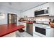 Well-lit kitchen featuring a stainless steel refrigerator, oven, and microwave with light cabinetry at 211 Pasadena N Ave # 109, St Petersburg, FL 33710