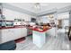 Functional kitchen with white cabinets, red countertops, stainless appliances, and tile backsplash at 211 Pasadena N Ave # 109, St Petersburg, FL 33710