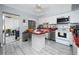 Bright kitchen with white appliances, red countertops, tile flooring, and ample cabinet space at 211 Pasadena N Ave # 109, St Petersburg, FL 33710