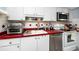 Functional kitchen with stainless steel appliances, red countertops, and light cabinetry at 211 Pasadena N Ave # 109, St Petersburg, FL 33710