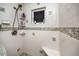 Shower with tiled bench, mosaic tile trim and hand held shower head at 211 Pasadena N Ave # 109, St Petersburg, FL 33710