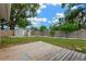 Spacious backyard featuring a wooden deck, mature trees, and a storage shed at 2325 W Knollwood Pl, Tampa, FL 33604