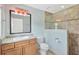 Bathroom with vanity and illuminated mirror, plus a walk-in shower with tiled walls and a glass door at 2325 W Knollwood Pl, Tampa, FL 33604